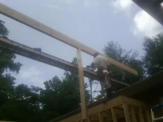 Carpenter setting a ridge beam over a new addition frame — Ice Dam Removal by Roofing Brothers in Harmony
